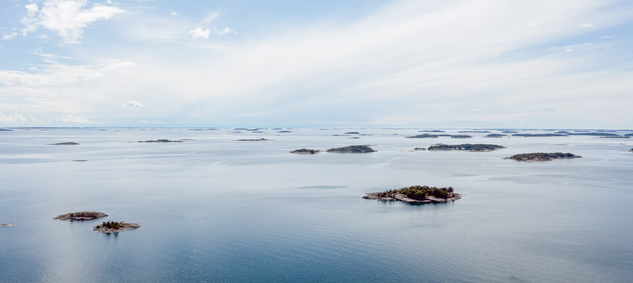 Ilmakuva saaristosta tyynenä kesäpäivänä.
