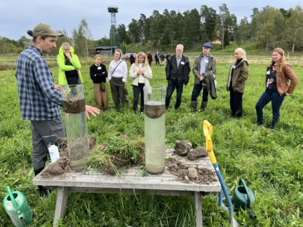 Ihmisiä seuraa viljelijän esitelmää maan tiivistymistä pellolla.